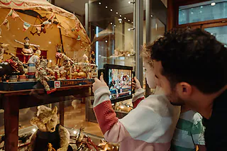 Ausstellung im Spielzeug Welten Museum Basel, Der Zirkusdirktor begüßt die Zuschauer.17.04.2023, BZ - LOR: Der Zirkusdirektor begrüßt die Zuschauer: Das Tablet schafft eine zusätzliche Ebene in der Dauerausstellung und macht sie lebendig. [Foto: Henry Freitag (SWMB)]