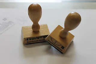 Jakobsweg-Stempel nun auch in Ettenheim und Ettenheimmünster  2 neue Stempel erinnern an die Station in Ettenheim und Ettenheimmünster   Der Jakobsweg ist der bekannteste Pilgerweg der Welt. Seit über 1000 Jahre wandern Pilger zum Grab des Apostels Jakobus in der spanischen Stadt Santiago de Compostela. Bereits im Mittelalter gehörte dieser Ort neben Rom und Jerusalem zu den bedeutendsten Wallfahrtsorten der Christenheit. In den letzten 30 Jahren hat die Pilgerschaft auf dem Jakobsweg einen großen Aufschwung erlebt. Der Europarat erklärte 1987 den Weg zum ersten europäischen Kulturweg. 1993 wurde der Camino francés in Spanien in die Liste der Weltkulturerbe der UNESCO aufgenommen. Im Laufe der Jahrhunderte haben sich viele verschiedene Routen mit eigenem Namen gebildet, die schon vor Jahrhunderten wegen ihrer Infrastruktur von den Pilgern bevorzugt wurden. Seit 2008 ist auch Ettenheim Teil des badischen Jakobusweges. Der südliche Teil dieser Strecke beginnt in Schutterwald und führt die Pilger über Lahr, Ettenheim, Weisweil, die Kaiserstuhl-Orte bis nach Breisach. Ettenheim könnte somit Ausgangspunkt als auch Station einer Wanderung auf der berühmten Pilgerroute sein. Als Nachweis für die zurückgelegte Strecke, dienen Pilgerstempel, den sich die Wanderer des Jakobsweges in den Pilgerpass drucken können. Der offizielle Pilgerpass ist unter anderem bei den Jakobsgesellschaften erhältlich. Auch in Ettenheim und Ettenheimmünster können sich die Pilger nun einen Pilgerstempel in ihren Pass drucken, denn ab sofort gibt es zwei Stempel für Pilger, die auf dem Jakobsweg in Ettenheim und Ettenheimmünster Station machen.  In Ettenheimmünster liegt er in der Barock- und Wallfahrtskirche St. Landelin und in der Ortsverwaltung aus. Der Stempel zeigt das Wappen von Ettenheimmünster, ein aus dem Unterrand des Wappens emporkommender Abtsstab, vor dem Schaft schräg gekreuzt ein goldener Palmzweig und ein goldenes Schwert.  In Ettenheim sind das katholische Pfarrbüro auf dem [Stadt Ettenheim]