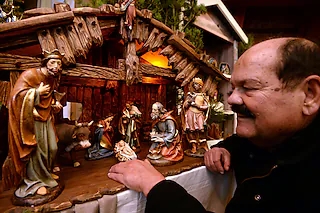 Hans-Peter Wagner, Ortsvorsteher in Unterharmersbach, kniet in der Krippenausstellung im Heimatmuseum Fürstenberger Hof in Zell am Harmersbach-Unterharmersbach (Baden-Württemberg) am 10.12.2013 vor einer Krippe aus dem Oberammergau. Mehr als 400 Krippen sind in der Ausstellung bis zum 06.01.2014 zu sehen. Foto: Patrick Seeger/dpa +++(c) dpa - Bildfunk+++ [Foto: Patrick Seeger]