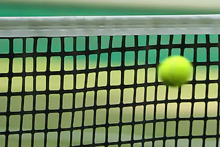 ARCHIV - 22.06.2017, Nordrhein-Westfalen, Halle: Ein Tennisball am Netz. Seit Jahren wird über einen Zusammenschluss von ATP und WTA diskutiert. In der Corona-Krise nimmt das Thema nun Fahrt auf. Foto: Friso Gentsch/dpa +++ dpa-Bildfunk +++28.10.2020, BZ - FLA: In Umkirch boomt der Tennis-Sport – weshalb dort nun neue Plätze angelegt werden sollen.14.11.2020, BZ - SPO: Erstmal kein Hallentennis in Bayern14.08.2021, BZ - OLA: Die Tennisplätze in Ringsheim und Ettenheim sind Austragungsorte der Kahlenberg Open. Friso Gentsch (DPA) [Foto: Friso Gentsch (dpa)]